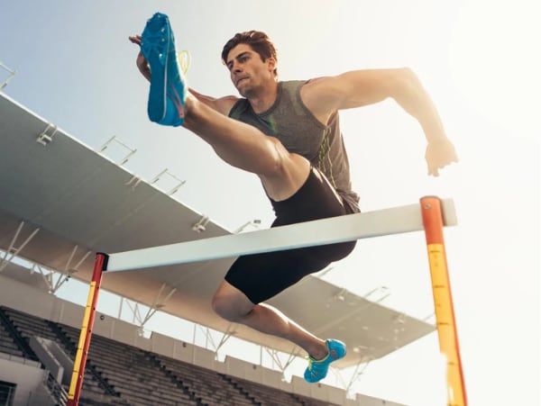Huerdenlaeufer im Stadion – gesunde Fuesse und Leistung im Sport.